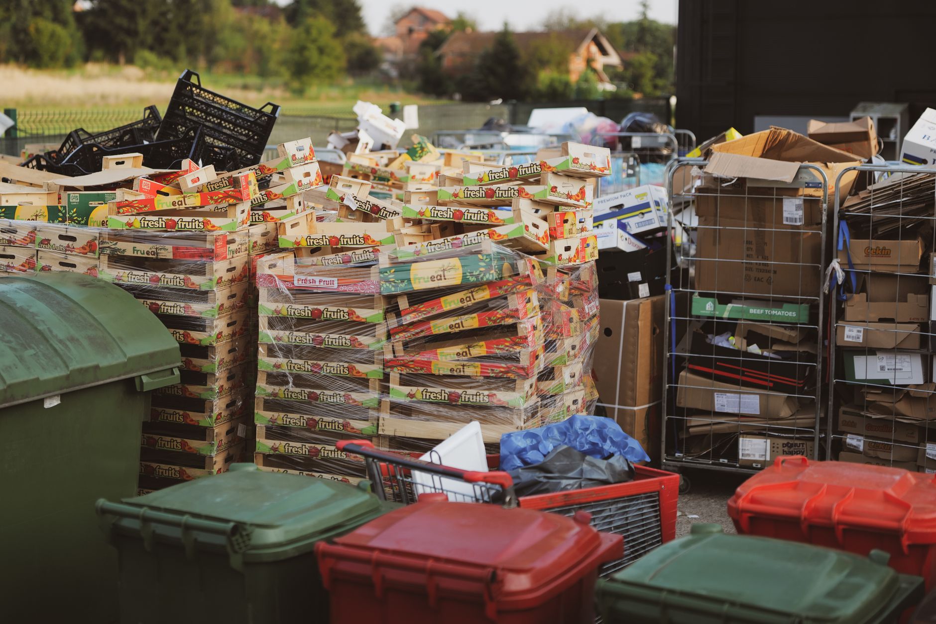 Stacks of carton boxes and bins in an outdoor storage area, exemplifying waste management.