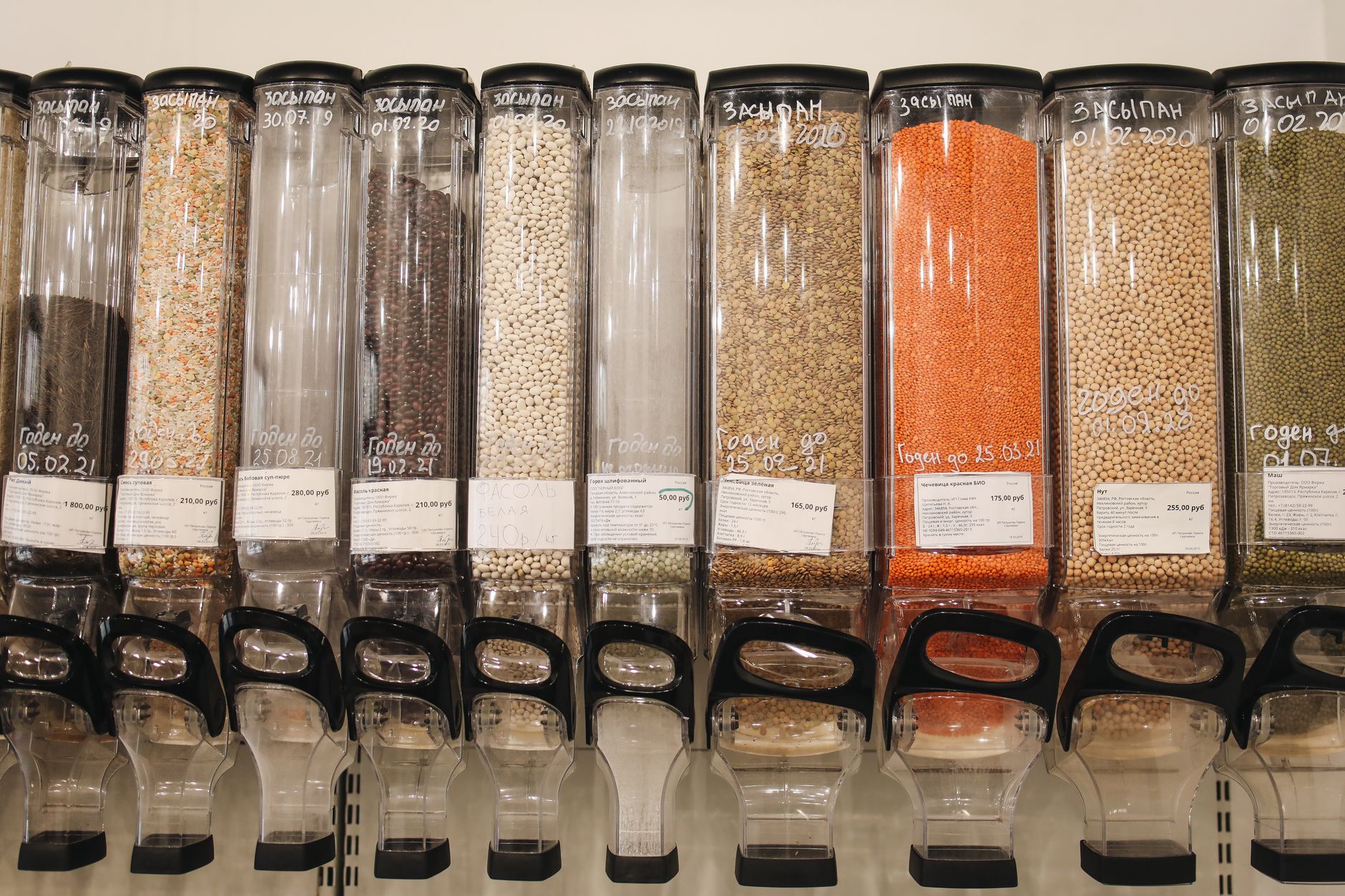 Row of eco-friendly bulk food dispensers in a shop promoting zero waste shopping.
