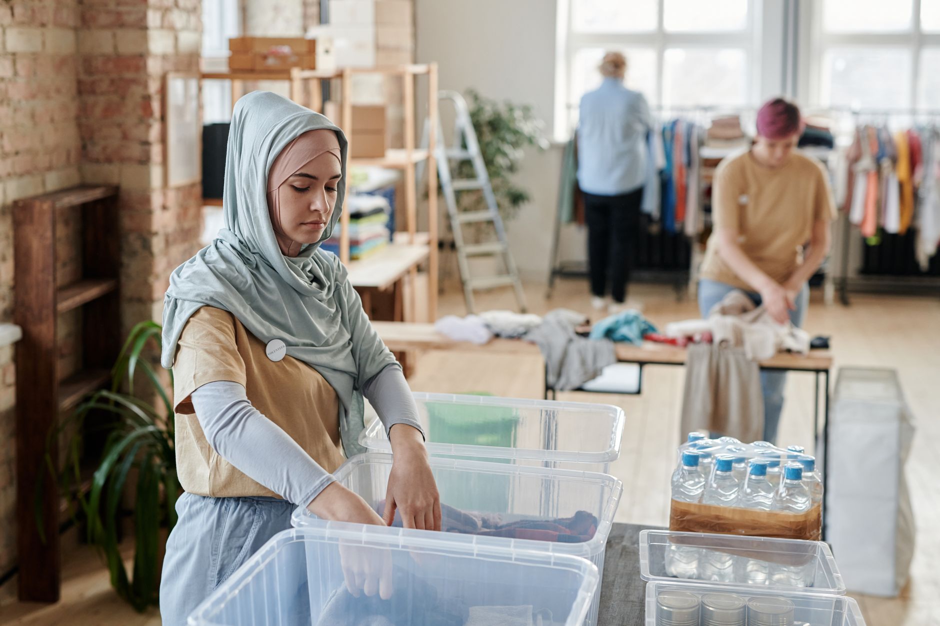Volunteers organize clothes at a donation center, demonstrating teamwork and community service.