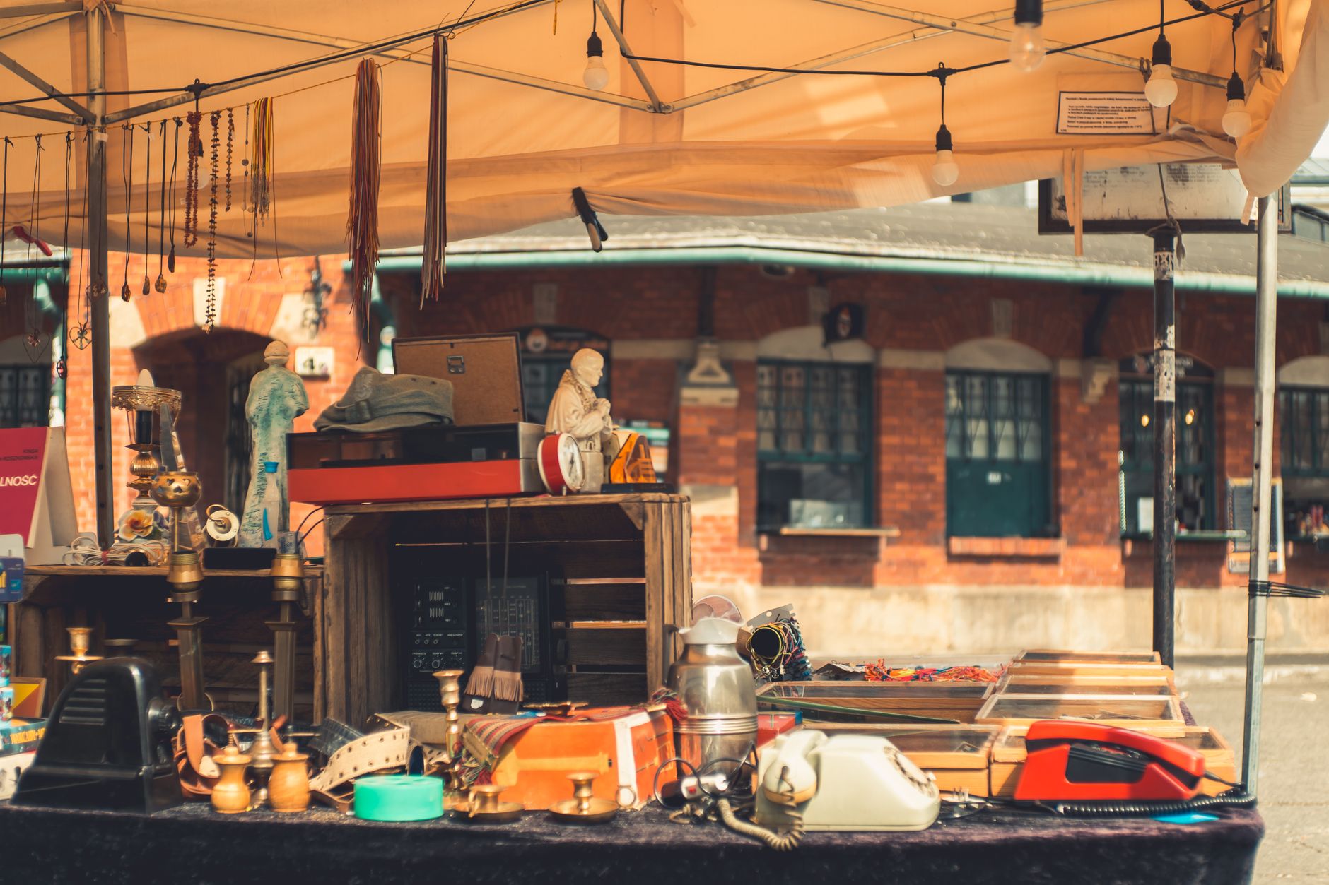 Explore a vibrant flea market stall in Krakow showcasing vintage treasures and eclectic decor under a sunny sky.
