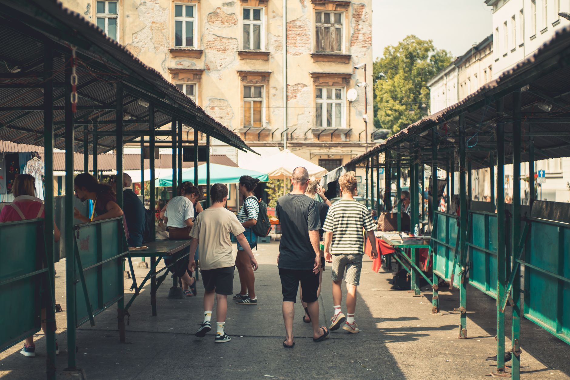 Crowds explore a vibrant outdoor market street in Kraków, Poland.