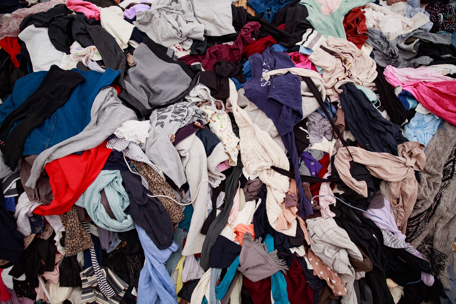 A large pile of mixed clothing suggesting recycling, donation, or decluttering.