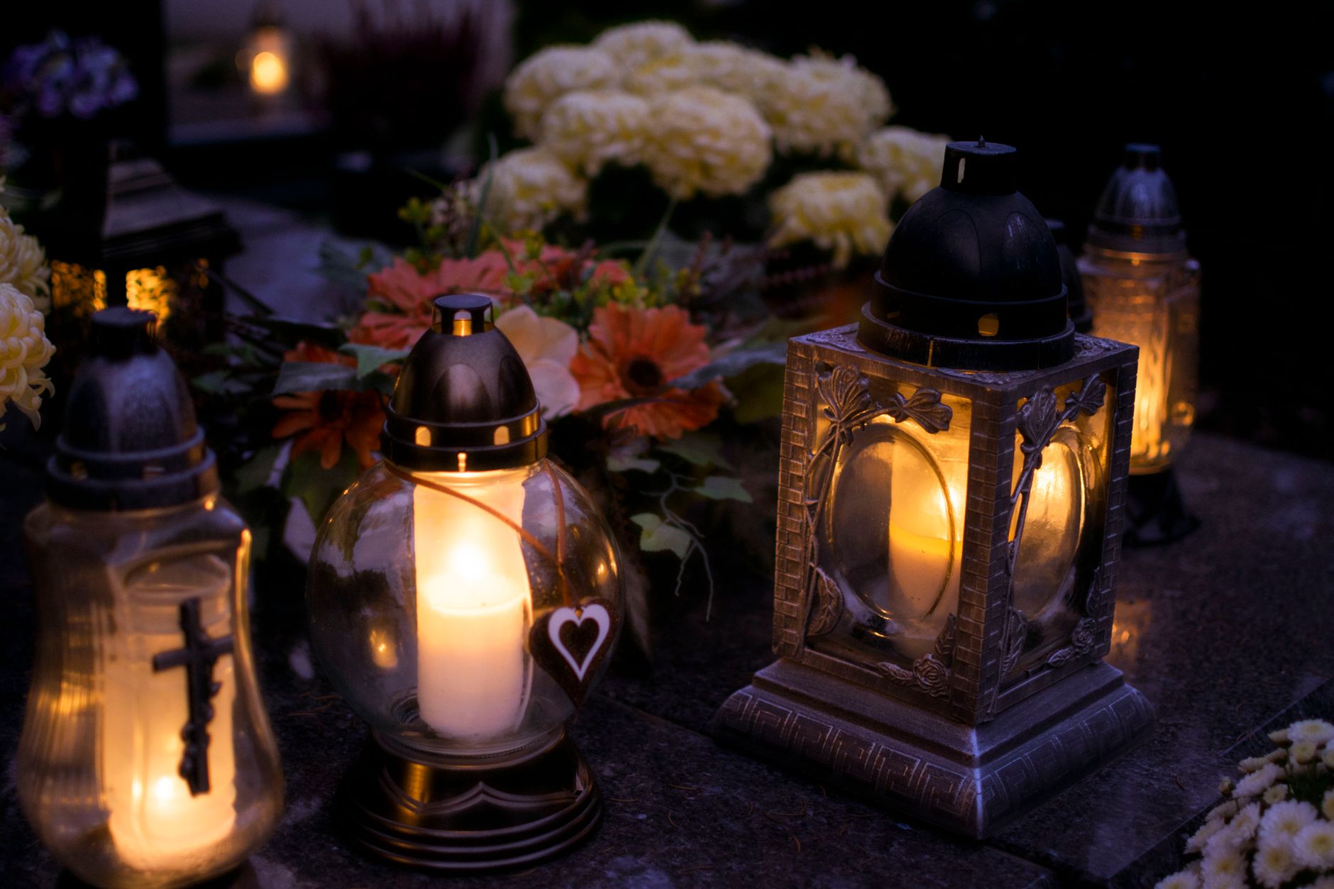 Lanterns with candles illuminate a cemetery on All Saints' Day.
