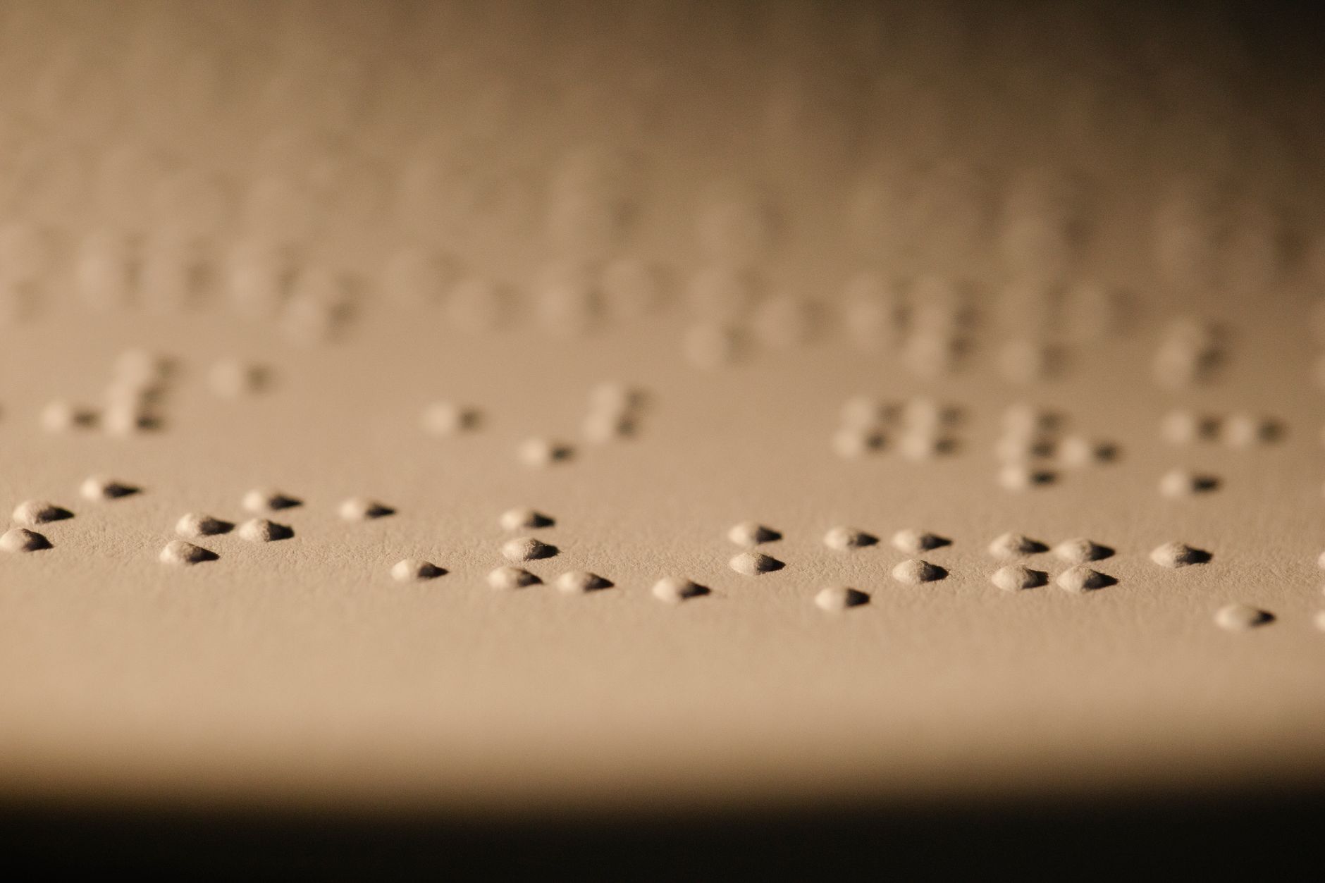 Macro shot of Braille dots embossed on paper, illustrating tactile reading for visually impaired.