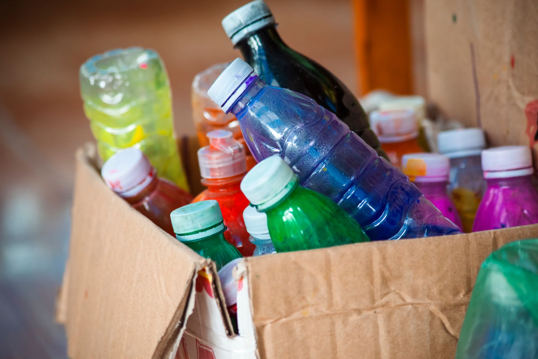 Vibrant array of plastic bottles stored in a cardboard box. Perfect recycling concept.