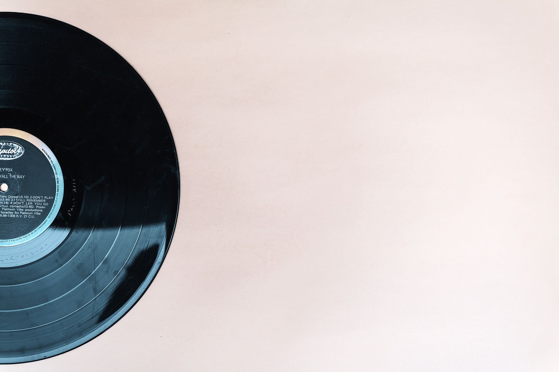 Close-up of a classic vinyl record with copyspace on a beige backdrop.