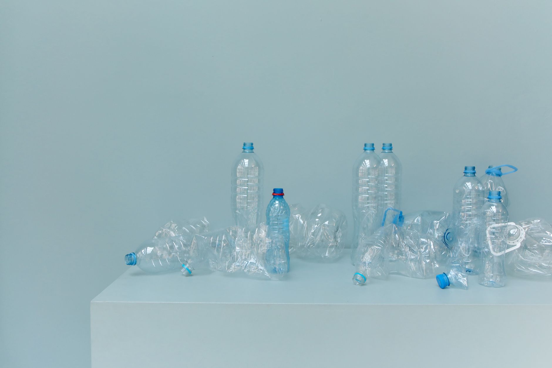 A collection of empty plastic bottles arranged on a white surface, highlighting recycled materials.