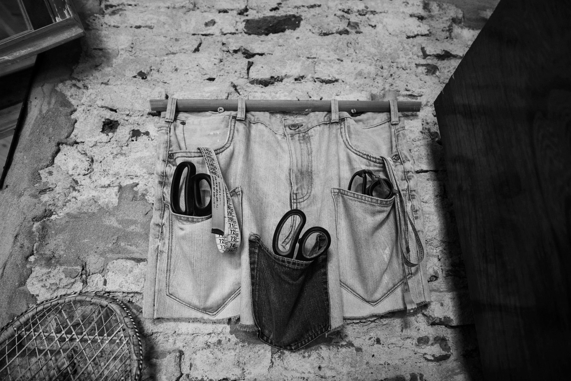 Stylish black and white wall decor featuring repurposed jeans holding scissors.