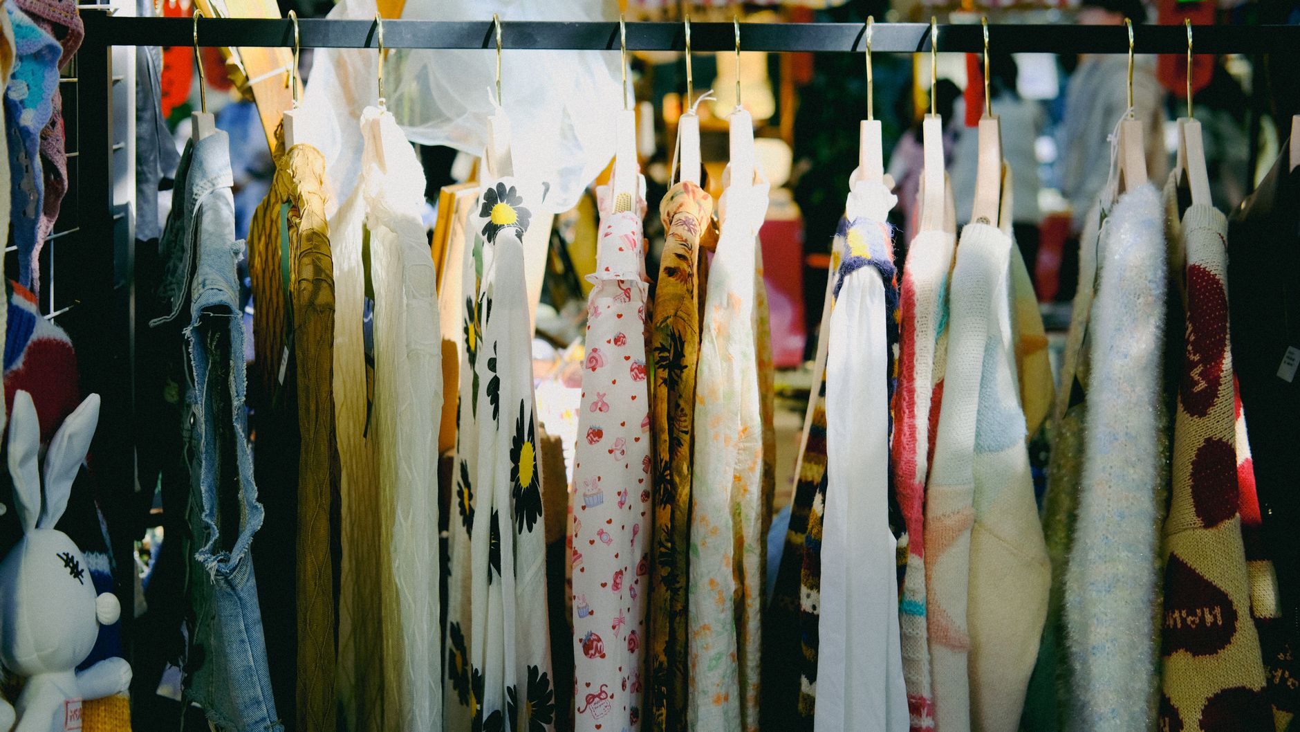 Colorful vintage clothing on display at an outdoor flea market.